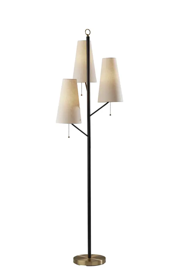 The Daniel floor lamp combines industrial style with practical functionality, featuring three offset arms with cream fabric shades. The black metal body with antique brass accents creates visual interest while providing flexible lighting options.