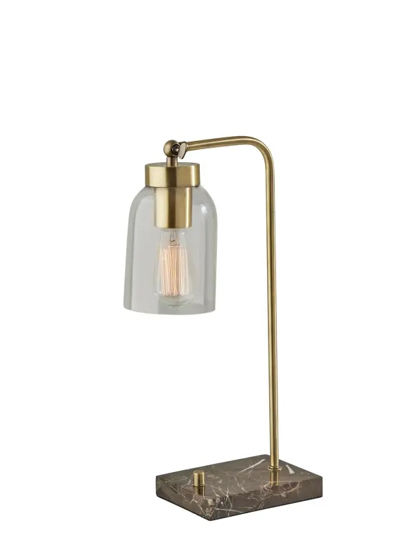 The Bristol desk lamp combines mid-century modern aesthetics with practical functionality. Featuring a luxurious brown marble base, antique brass finish, and clear glass dome shade that showcases a vintage Edison bulb, this 19-inch lamp adds sophisticated task lighting to any workspace or bedside.