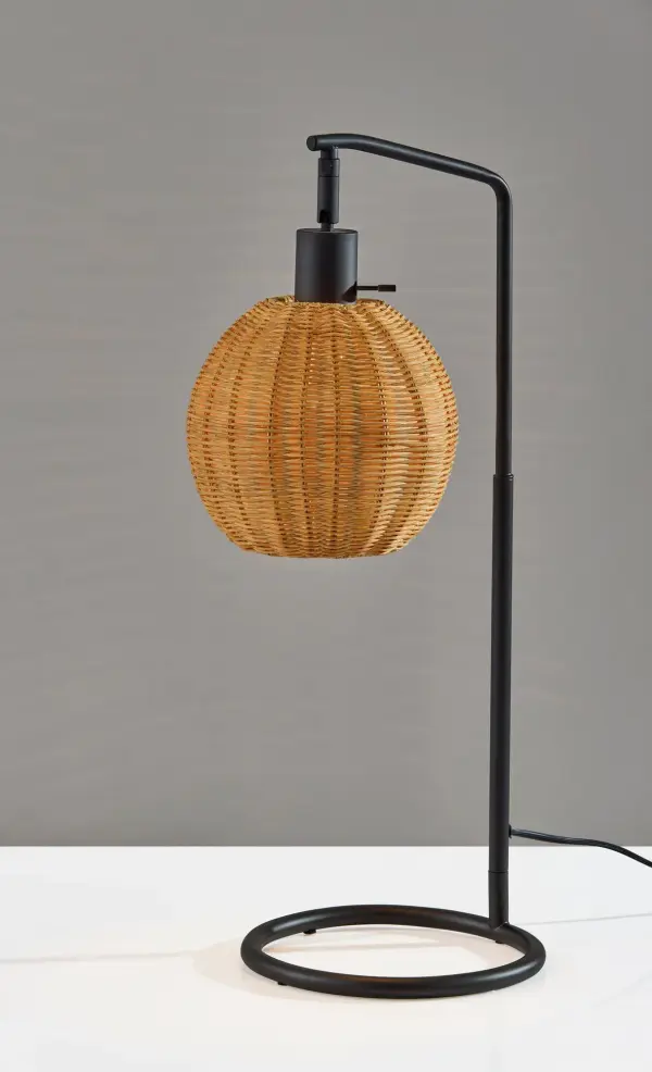 The Maeve Table Lamp masterfully combines contemporary black metal with organic rattan textures. Its open ring base and globe-shaped shade create visual interest while casting a warm, inviting glow perfect for intimate spaces.