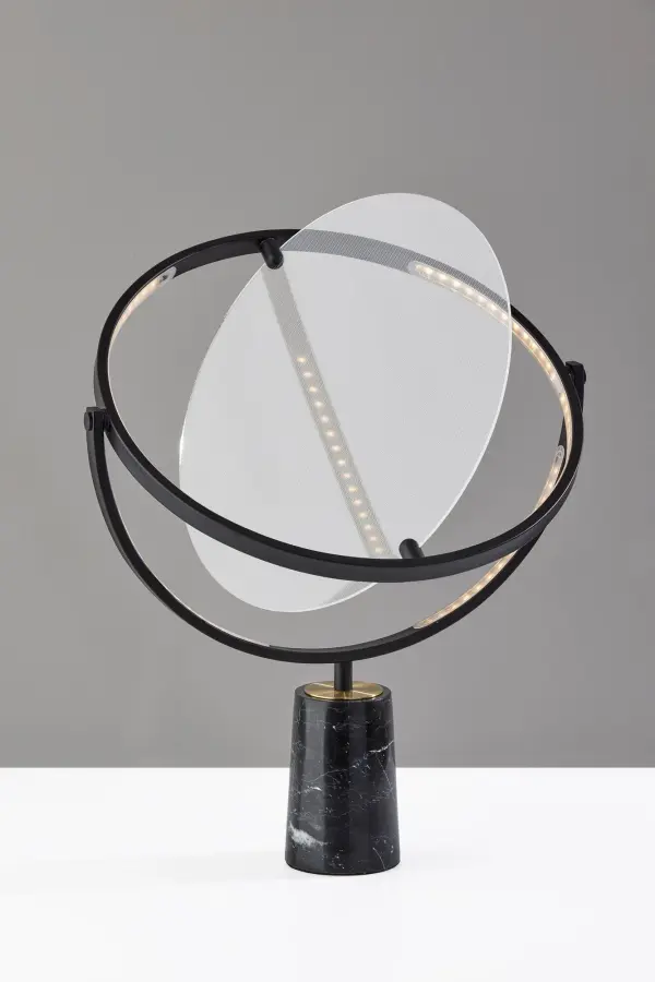 The Orsa LED table lamp combines artistic design with practical functionality. Its rotating 17" disc-shaped LED frame and luxurious black marble base create a striking statement piece that delivers 1,000 lumens of adjustable lighting. - alternate view