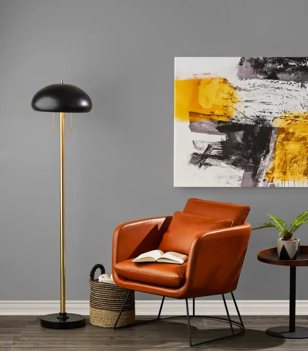 The Stanley Chair blends 70's bohemian charm with contemporary design through its distressed camel brown faux leather upholstery and sleek matte black metal frame. Generous seating dimensions and included accent pillow deliver comfort. - alternate view