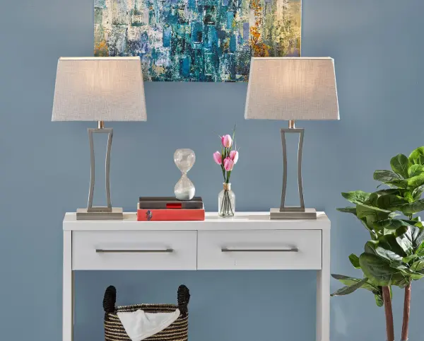 The Camila table lamp set delivers contemporary style with brushed steel open rectangular frames and grey-white woven fabric shades. At 24.25" height, this matching pair creates cohesive symmetry for bedside tables or console styling. - alternate view