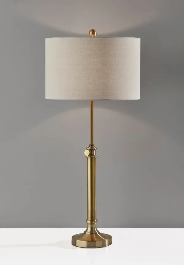 The Barton Table Lamp combines modern farmhouse charm with practical functionality. Its adjustable height feature (26-34.5 inches) and warm antique brass finish make it adaptable to various room settings and furniture heights. - alternate view