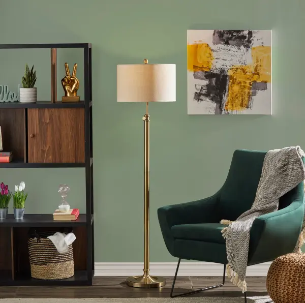 The Barton Floor Lamp combines functionality with style, featuring an adjustable height mechanism (57-65.5 inches) and warm antique brass finish. The oatmeal linen shade provides soft, ambient lighting perfect for reading or relaxing. - alternate view