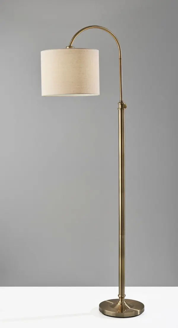 The Barton task floor lamp combines timeless antique brass styling with practical adjustability. Its height adjusts from 58 to 68 inches, making it perfect for reading corners or beside seating. The oatmeal linen shade softly diffuses light while rich detailing complements traditional and transitional interiors. - alternate view