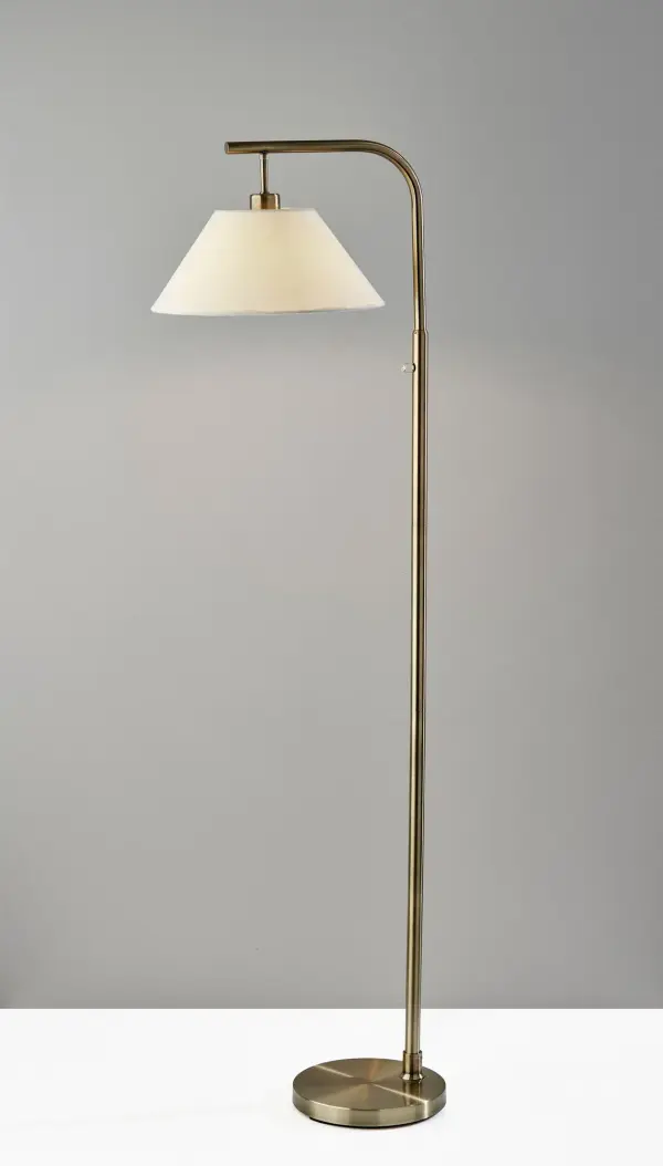The Hayes floor lamp combines clean lines with a graceful arcing arm, finished in warm antique brass. Its textured white fabric shade diffuses light beautifully, making it ideal for reading corners or beside furniture. - alternate view