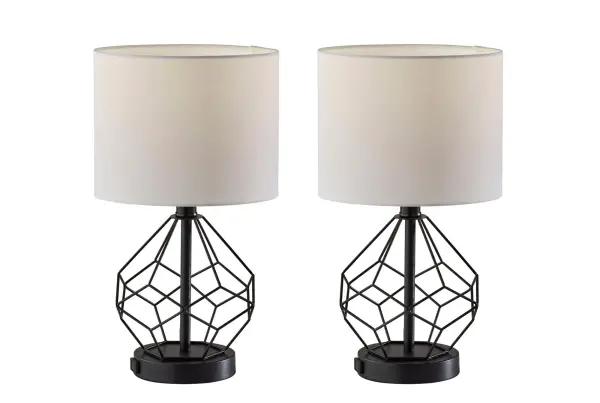 The Chiara 2-piece lamp set delivers contemporary industrial style with practical built-in AC outlets for device charging. Black metal cage bases paired with white fabric shades create striking contrast while the compact 16-inch height fits perfectly in smaller spaces.
