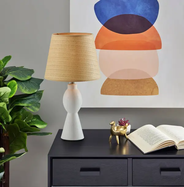 The Everest Table Lamp combines a clean white ceramic base with a handwoven rattan shade, creating a perfect blend of coastal charm and organic modern style. At 25.5 inches tall, it provides excellent task and ambient lighting. - alternate view