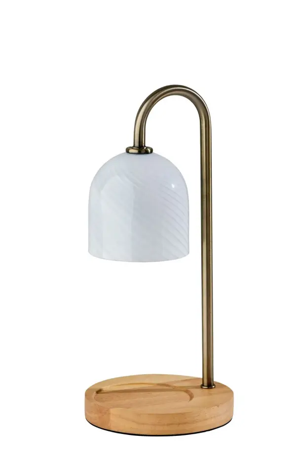 Timeless beauty meets everyday comfort in the Alcott Candlewarmer Lamp. Featuring an antique brass pole and a dome-shaped swirled white glass shade, this piece evokes the charm of heirloom lighting—reimagined for modern living. Its natural wood base includes a sculpted candle well to cradle your favorite jar candle, while a 50W halogen bulb safely warms the wax without a flame. The in-line switch offers a full-range dimmer and timer, allowing you to tailor the ambiance to any mood or moment. Whether setting the scene for a quiet evening or elevating a guest space, Alcott casts a warm, welcoming glow that feels as luxurious as it looks. Collection: Alcott Finish: Antique Brass Glass: Swirled Glass Width: 6.00" Height: 13.00" Length: 6.00" Weight: 2.56 lb Extension from Wall: 6.00" Wire: 60" silver Cord Bulbs Included Maximum Wattage: 50.00 W Bulb Base: GU10 Light Source: Halogen Material: Wood:40%, Metal:20%, Glass:30%, Electrical parts:10% Country of Origin: Cambodia Safety Listing: ETL Switch: In-Line Timer Switch Connection: Plug-in