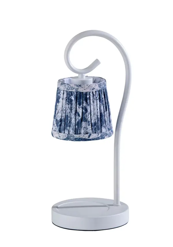 Charming, cheerful, and effortlessly cozy—the Perry Candlewarmer Lamp brightens any room with timeless cottage charm. A soft white metal base with a curved pole supports a pleated fabric shade adorned in a delicate blue floral print, bringing vintage-inspired elegance to your candle ritual. With a 50W halogen bulb to gently warm your favorite jar candle, you'll enjoy its fragrance without flames or smoke. The full-range dimmer and built-in timer offer total control, so you can set the mood and let the glow do the rest. Collection: Perry Finish: White Glass: Blue Floral Printed Fabric Width: 6.00" Height: 14.50" Length: 6.00" Weight: 2.90 lb Extension from Wall: 6.00" Wire: 60" silver Cord Bulbs Included Maximum Wattage: 50.00 W Bulb Base: GU10 Light Source: Halogen Material: Metal:60%, Fabric:30%, Electrical parts:10% Country of Origin: Cambodia Safety Listing: ETL Switch: In-Line Timer Switch Connection: Plug-in