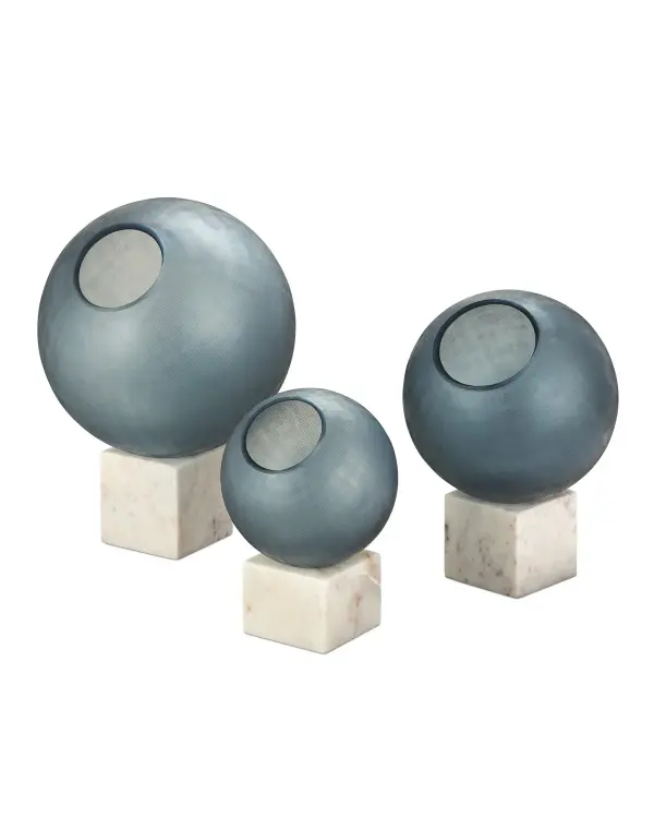 This three-piece decorative set features handcrafted glass orbs in indigo blue and white with a distinctive bubbly texture. Each orb rests on a white marble base, creating an elegant display that catches natural light beautifully.