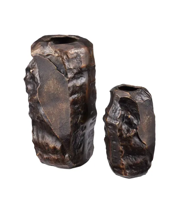 These cast aluminum vases bring architectural drama with their organic brutalist forms and warm scorched bronze finish. The substantial weight and artisanal welded construction create statement pieces that anchor any space.