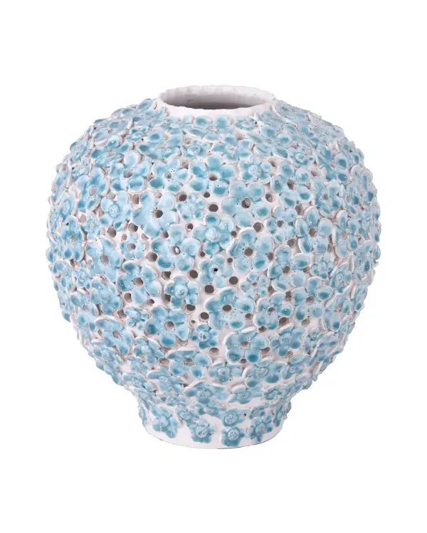 This artisan-made ceramic vase showcases hand-placed blue forget-me-not flowers and intricate pierced detailing. Its handcrafted nature ensures each piece is unique, making it a distinctive decorative accent for coastal or organic modern interiors.