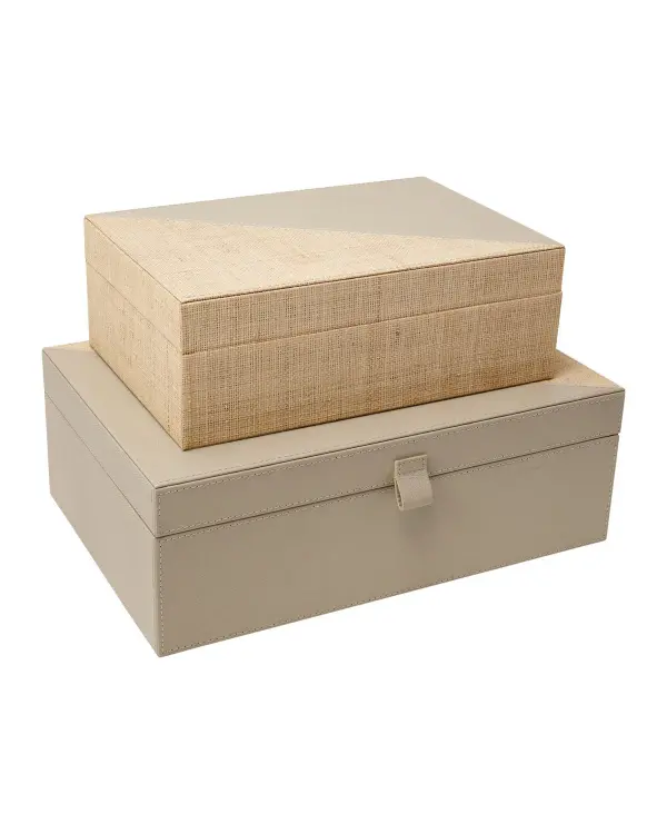 This two-piece decorative box set combines natural ivory raffia with gray leather for a refined, textural look. The neutral palette and clean lines work across traditional to contemporary interiors, offering stylish storage for any room.