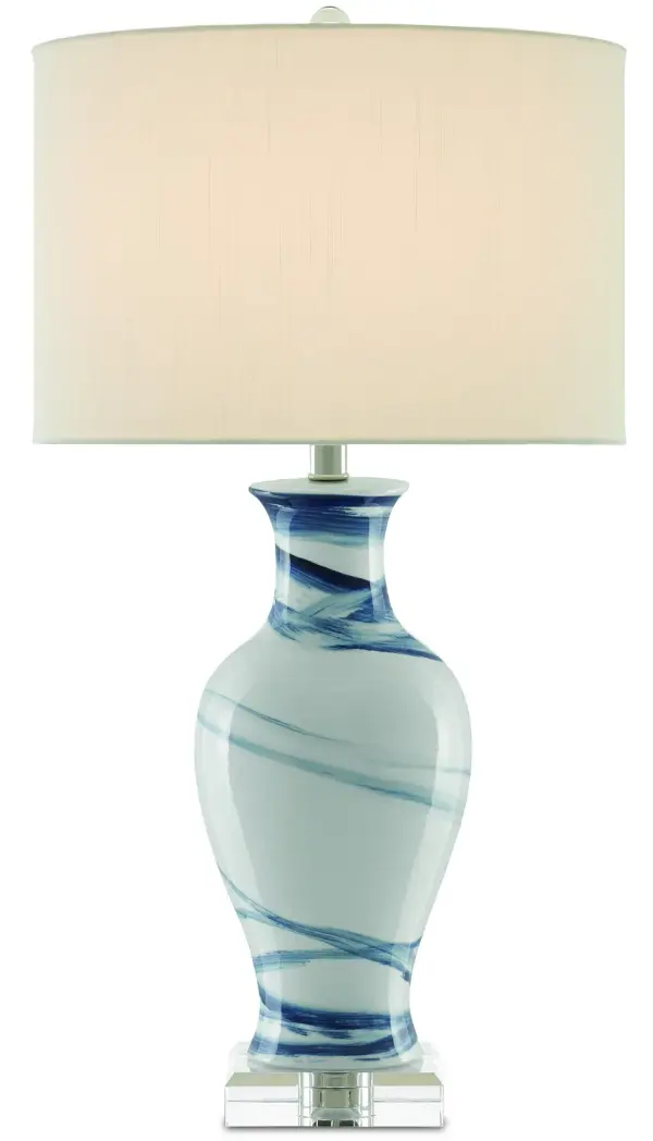 The Hanni Table Lamp combines traditional porcelain craftsmanship with coastal-inspired navy blue brushstrokes. Its optic crystal base and nickel hardware add refined luminosity, while the off-white shantung shade provides warm, diffused light.