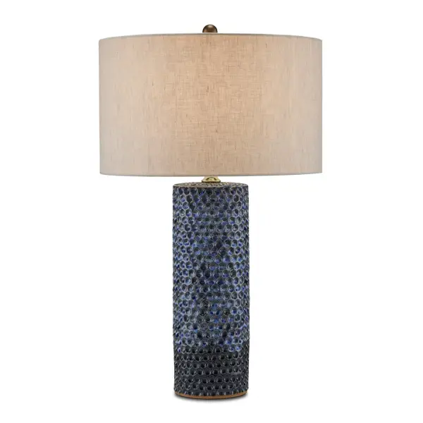 This handcrafted ceramic table lamp features a unique pressed polka dot pattern with reactive blue glazing that creates organic color variations. The natural linen shade softens the light while the sculptural base serves as a statement piece.