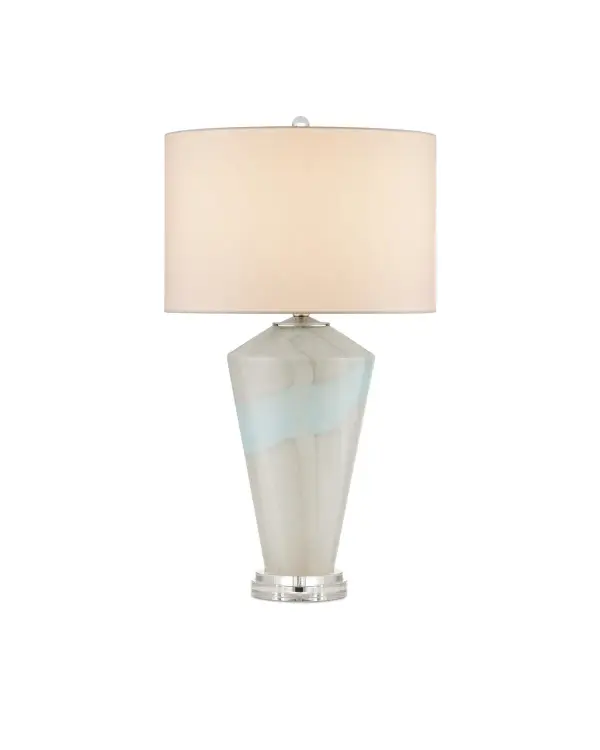 A stunning artisanal table lamp featuring mouth-blown glass with pale blue drifts on a textured gray surface. Each piece is unique, created by two artisans working in tandem. The optic crystal base and polished nickel accents elevate its sophisticated aesthetic.