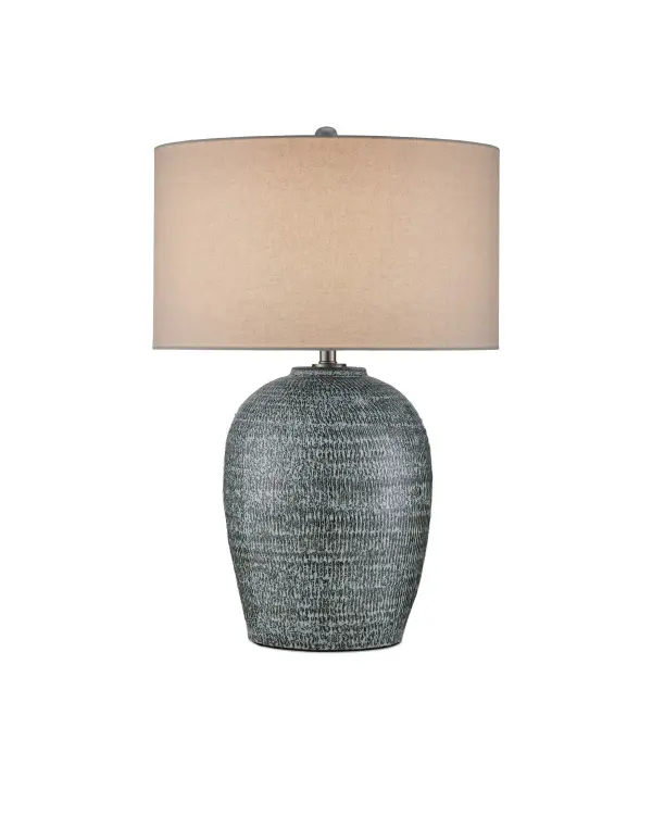 The Agatha Table Lamp showcases handcrafted ceramic artistry with a reactive black and white glaze that creates unique striations and color variations. Its substantial presence and textural quality make it a statement piece.
