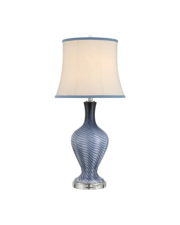 The Zeta Blue Table Lamp features hand-crafted grayish-blue glass with a distinctive swirling pattern that evokes ocean waves. Its substantial 33-inch height and optic crystal accents create visual impact while the 3-way switch offers lighting flexibility.