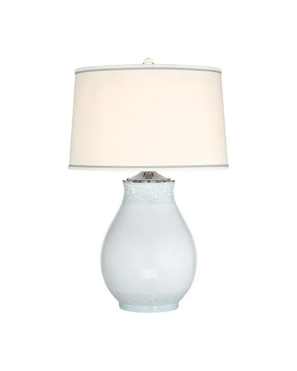 The Ketty Large Table Lamp has a beautiful porcelain body covered in a Chinese cloud motif on the top and bottom, the rings of ornamentation framing the glazed surface in between. The shade has a double trim, the inner portion matching the glaze on the body to bring the pale blue table lamp a very refined profile. The Celadon color is complemented by the metal in a polished nickel finish. Collection: Ketty Finish: Off-White / Celadon Green Glass: Off White & Green Polyester Width: 21.00" Height: 33.00" Weight: 20.00 lb Wire: 6' Clear Silver Number of Bulbs: 1 Maximum Wattage: 150.00 W Bulb Type: A Bulb Base: E26 Voltage: 120.00 V Material: Porcelain Country of Origin: China Switch: 3-Way Turn Knob Manufacturer Warranty: One year against defects in materials and workmanship
