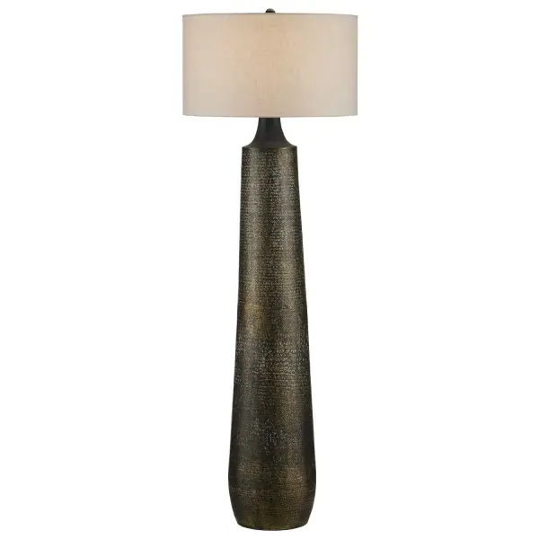 A statement floor lamp featuring hand-hammered cast aluminum with layered antique gold, black, and whitewash finishes. The textured, pitted surface creates visual depth while the off-white linen drum shade softens the industrial aesthetic.