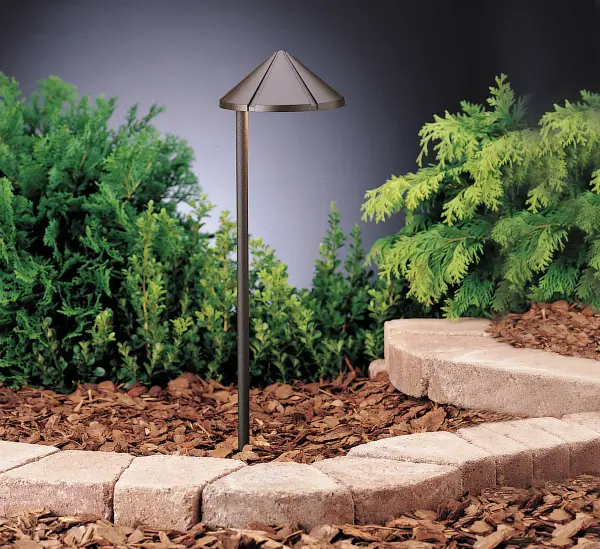 The Six Groove path light delivers focused, glare-free illumination with its side-mount design. Compact aluminum construction in textured bronze finish suits contemporary outdoor spaces. Low-voltage operation provides energy efficiency.