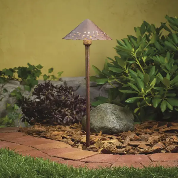 This hammered aluminum path light creates beautiful patterned illumination along walkways and garden beds. The textured bronze finish and handcrafted aesthetic bring warmth to outdoor spaces while the low-voltage design ensures safety and efficiency.