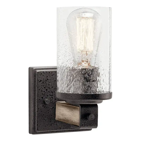The Barrington Wall Sconce blends rustic farmhouse warmth with industrial character. Featuring distressed wood accents, anvil iron finish, and clear seeded glass, this compact fixture adds authentic charm to any space.