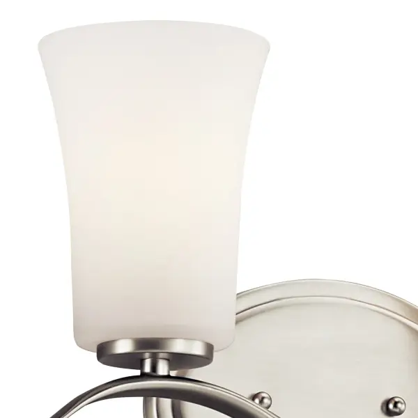 The Armida 2-light vanity fixture combines transitional styling with practical features. Its brushed nickel finish and clear satin etched glass shades provide even illumination, while dimmable capability and damp rating make it suitable for various bathroom environments. - alternate view