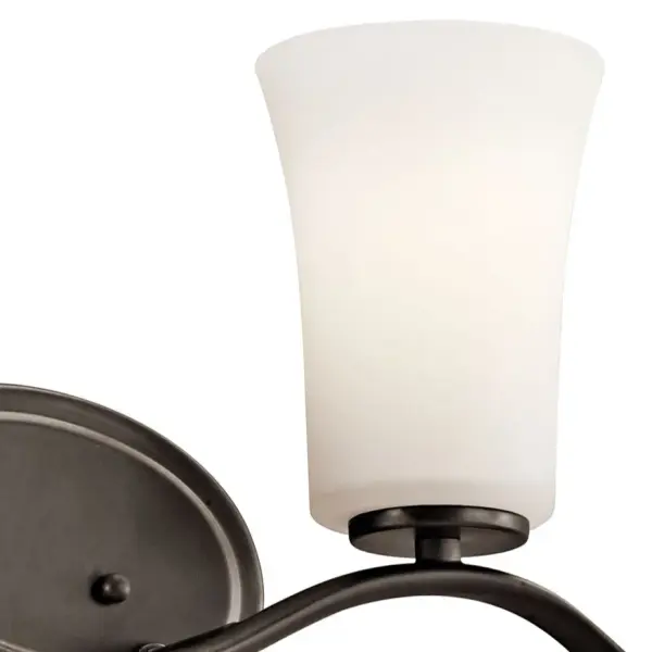 The Armida 2-Light Vanity Light combines traditional styling with practical functionality. Its Olde Bronze finish and clear satin etched glass shades provide warm, diffused illumination perfect for bathroom tasks. - alternate view