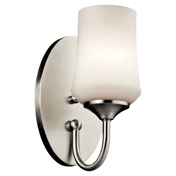 The Aubrey Wall Sconce combines brushed nickel finish with satin etched opal glass for a refined, versatile look. Its compact 10.75" height and reversible mounting make it ideal for bathrooms, hallways, and bedrooms.