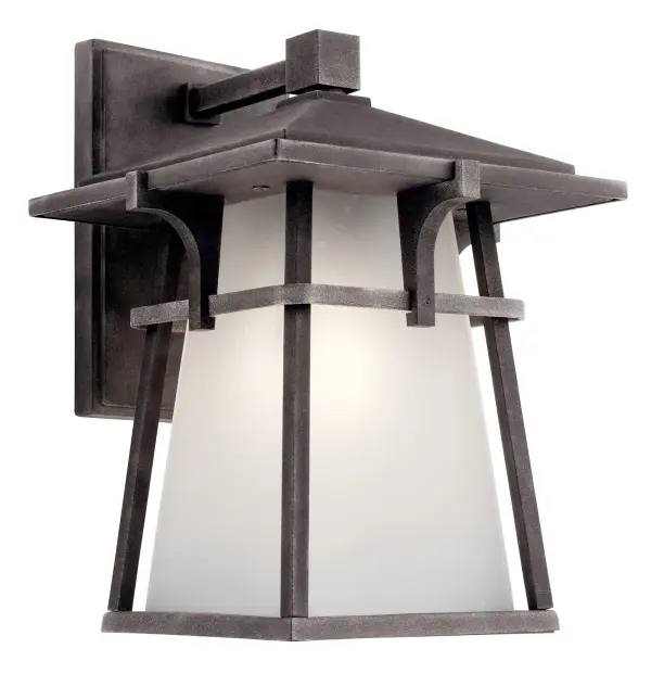 The Beckett Outdoor Wall Light combines transitional style with practical outdoor durability. Its weathered zinc finish and seeded glass shade create visual interest while providing reliable illumination for entryways and patios.