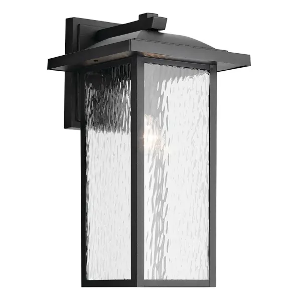 The Capanna outdoor wall light combines transitional style with durable wet-rated construction. Its textured black finish and clear water glass shade create visual interest while providing reliable illumination for exterior spaces.