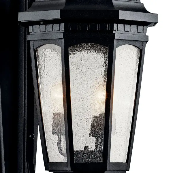 The Courtyard 3-light outdoor wall sconce brings substantial presence at 40.5" tall with classic seeded glass panels and textured black finish. Wet-rated for all weather conditions and dimmable for ambiance control. - alternate view
