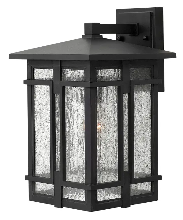 The Tucker LED Wall Mount combines sturdy cast aluminum construction with clear seedy glass for a rustic lodge aesthetic. Its geometric symmetry and wet-rated durability make it ideal for exterior applications.