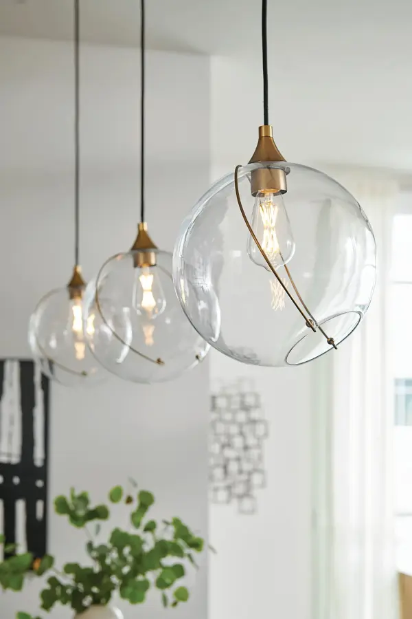 Mesmerizingly asymmetrical with a bohemian, midcentury modern flair, Skye showcases a stunning globe of clear or cased opal glass with an off-center opening. A slender ring and delicate details in a Heritage Brass or Black finish pull the look together, while an adjustable wire allows you to create the perfect look for your space. - alternate view