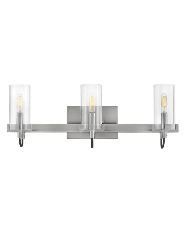 The Ryden LED vanity combines industrial design elements with contemporary elegance. Clear glass cylinders showcase integrated LED bulbs while cast prongs and ribbed details add visual interest. Fabric-wrapped cords enhance the artisanal quality.