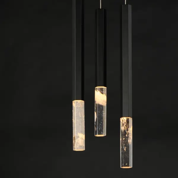 The Diaphane pendant showcases naturally translucent rock crystal blocks in hexagonal aluminum tubes, creating a stunning display of refracted light. Each stone's unique translucency ensures no two fixtures are identical, offering artisanal character with modern LED efficiency. - alternate view