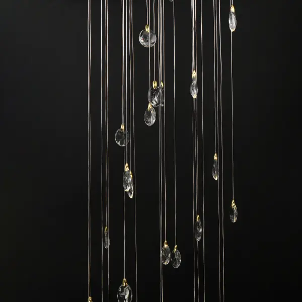 The Pebble Multi-Tier Chandelier transforms natural riverbed inspiration into a breathtaking lighting sculpture. Irregularly shaped crystal pebbles suspended by polished gold clasps create an iridescent shimmer, while concealed LEDs and downlighting deliver both ambiance and function. - alternate view