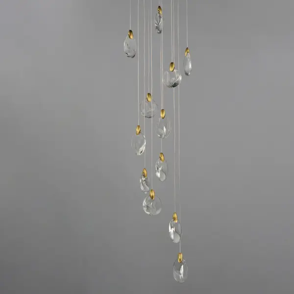 The Pebble pendant transforms natural river stone inspiration into a stunning 12-light fixture. Irregularly shaped crystal pebbles suspended by polished gold clasps create an organic, sculptural presence while concealed LEDs produce a mesmerizing iridescent shimmer. - alternate view