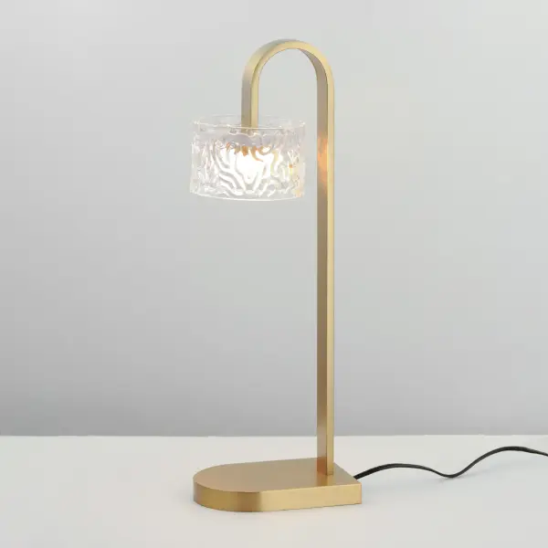 The Elysian table lamp combines clear glass cylinders with rippled crystal accents on a Natural Aged Brass frame. Integrated LED backlighting creates a luminous, artistic composition perfect for modern interiors. - alternate view