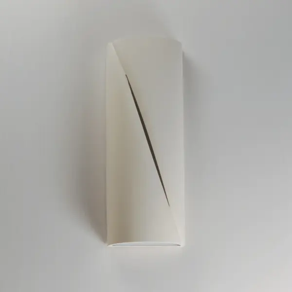 The Puff outdoor wall sconce combines architectural concrete construction with sophisticated lighting design. Its softly rounded form and diagonal reveal create ambient illumination while adding contemporary style to exterior spaces. - alternate view