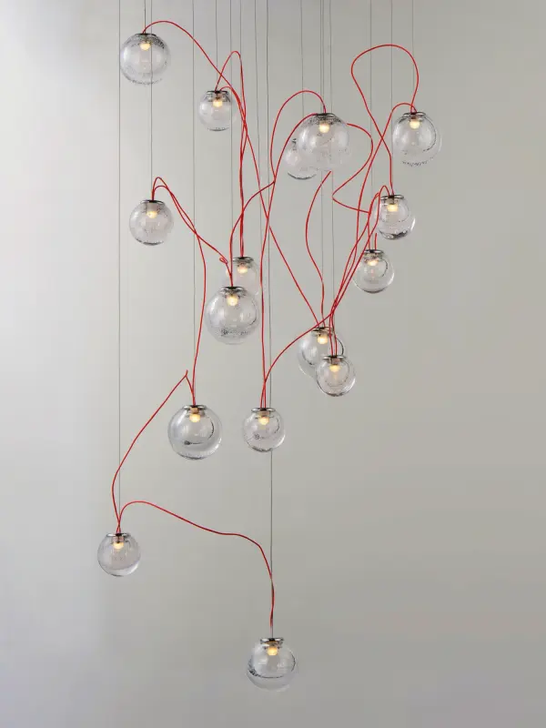 The Bobble pendant creates a galaxy-like artistic statement with 16 LED-lit bubble glass spheres suspended on contrasting red cords. Its polished chrome finish and integrated LEDs deliver modern sophistication for grand spaces. - alternate view