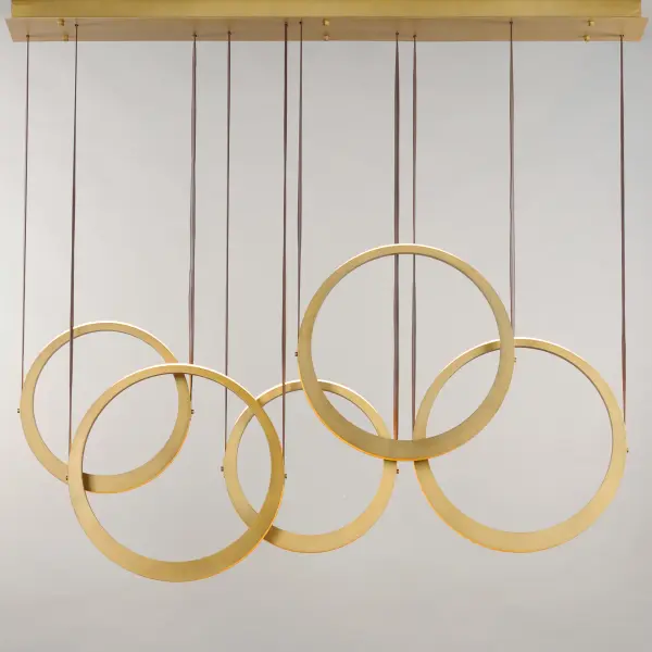 The Tether pendant combines industrial materials with refined design, featuring tapered brass rings suspended by leather straps. Concealed LED sources create dramatic indirect lighting that illuminates neighboring rings and spaces above and below. - alternate view