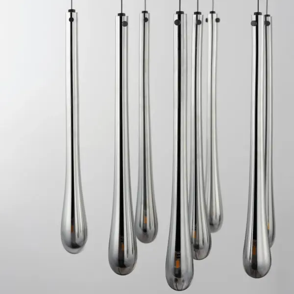 The Stillo collection elevates the classic teardrop pendant with hand-blown elongated glass shades and integrated LED technology. Nine lights create dramatic visual impact while energy-efficient G4 LEDs provide warm illumination. - alternate view