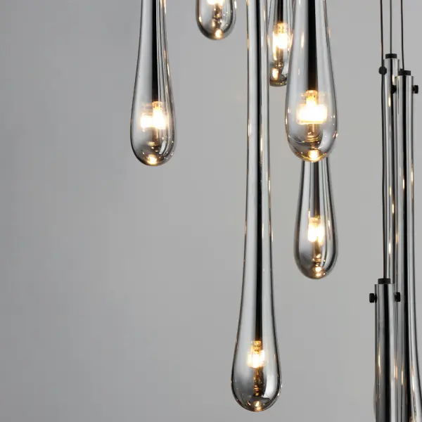 The Stillo transforms any space with 18 elongated hand-blown glass pendants featuring mirror smoked glass and matte black metalwork. Dense glass walls create dramatic visual impact while energy-efficient LED G4 lamps provide warm illumination. - alternate view