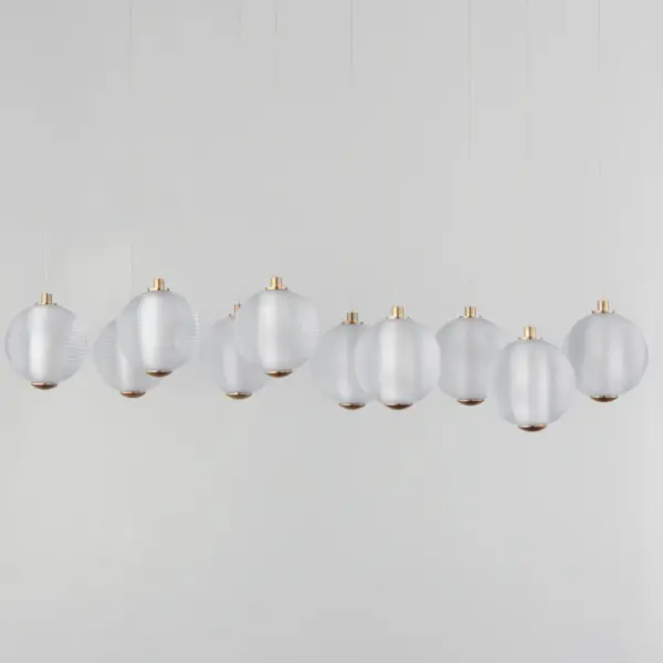 The Rhythm Linear Pendant makes a bold statement with ten perfectly ribbed glass spheres radiating omnidirectional LED light. The lustrous glow accentuates the repeating pattern while minimal hardware keeps focus on the sculptural design. - alternate view