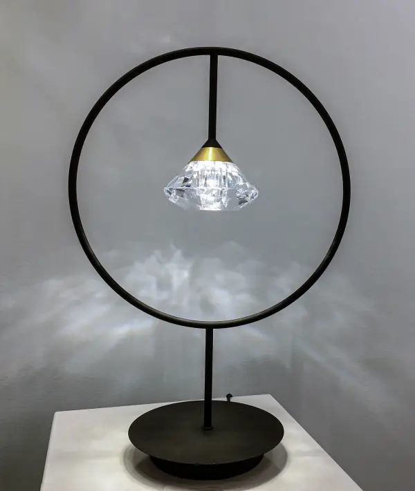 The Hope LED Table Lamp combines artistic design with practical functionality. Its sweeping arms create a sculptural silhouette while the pivoting arm provides adjustable bedside lighting. The faceted acrylic diamond adds visual interest. - alternate view
