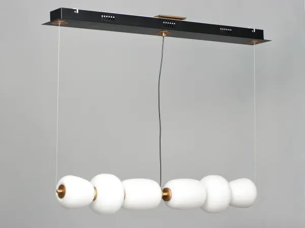 The Soji Linear Pendant brings serene sophistication to modern spaces with its Japanese lantern-inspired design. The 40-inch profile features Satin White glass diffusers suspended in a striking Black and Gold two-tone frame, delivering 1570 lumens of warm 3000K light. Perfect for kitchen islands and dining areas seeking refined contemporary style. - alternate view