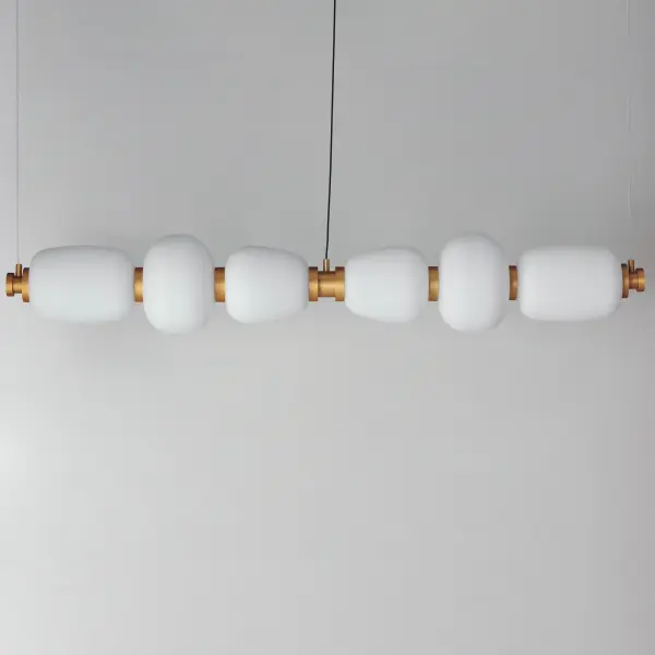 The Soji Linear Pendant brings quiet sophistication to modern spaces with its Japanese lantern-inspired design. The 60-inch length and bold Black/Gold two-tone frame create dramatic visual impact while Satin White glass diffuses 3000 lumens of warm 3000K light. Perfect for dining rooms and kitchen islands seeking architectural statement lighting. - alternate view